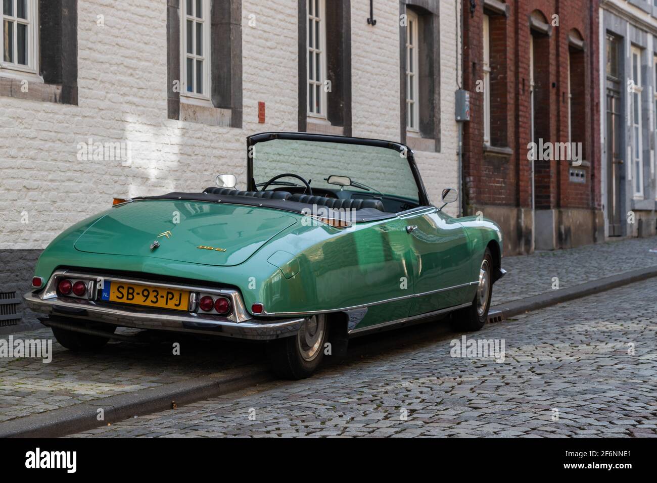 classical Citroën DS 21 car parked in the historical city centre of Maastricht. The car fits to the ancient environment and matches with cobblestones Stock Photo