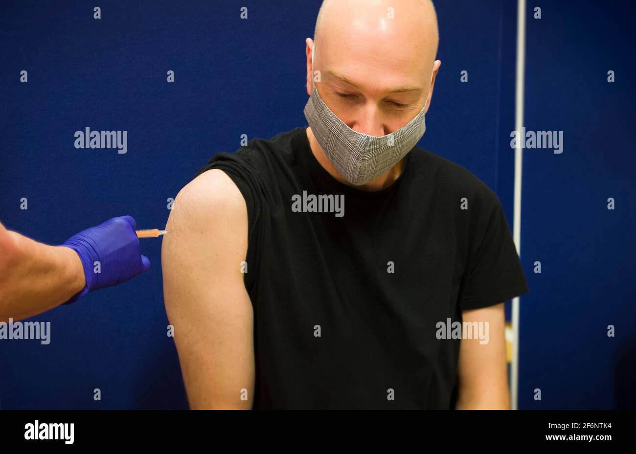 Middle aged white, Caucasian man wearing a face mask, getting a Covid 19 vaccine injection, England, UK Stock Photo