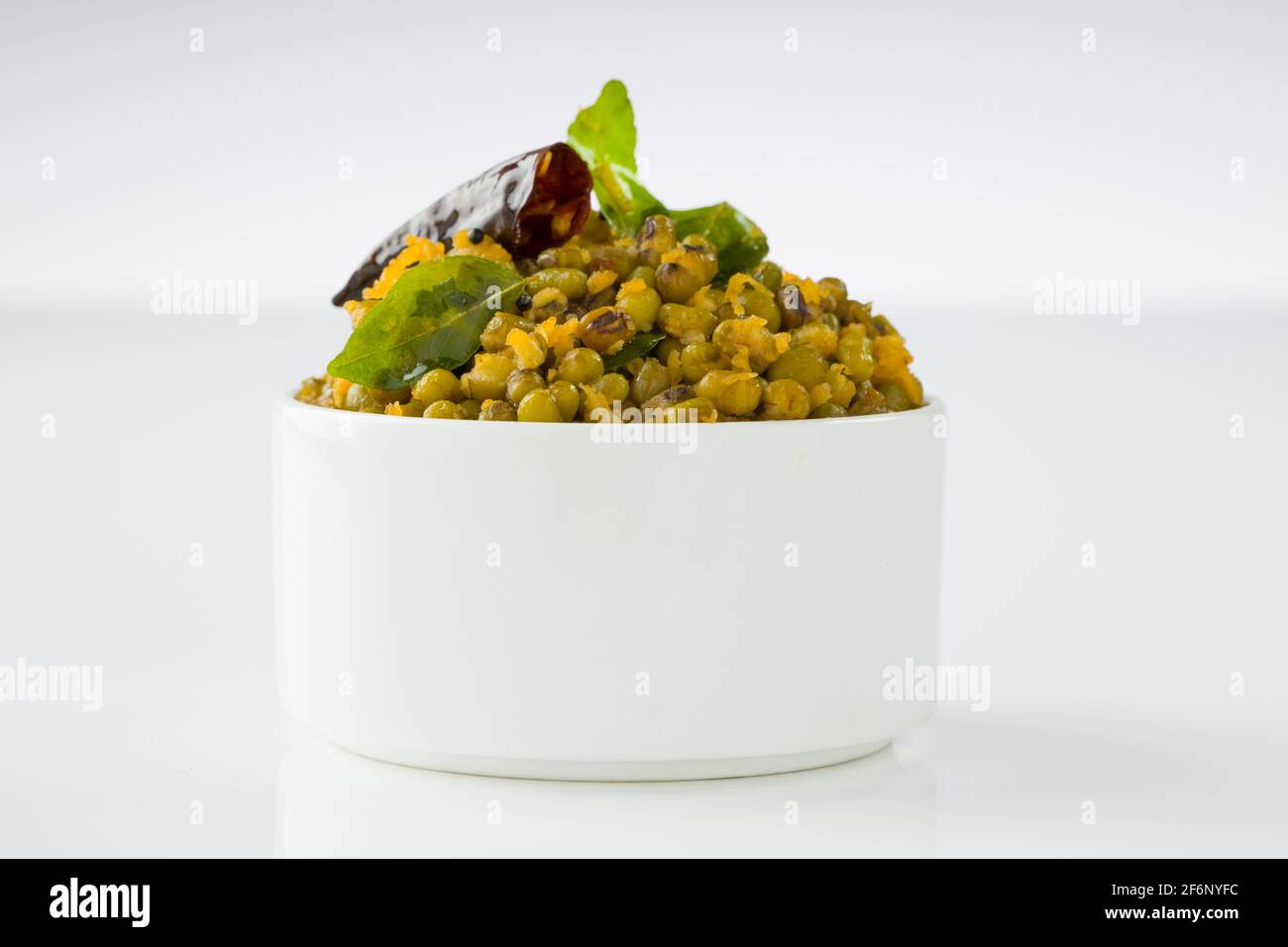 Green gram stir fry or mung bean dry fry,kerala common dish which is very healthy and tasty and it is arranged in a white bowl with white textured bac Stock Photo