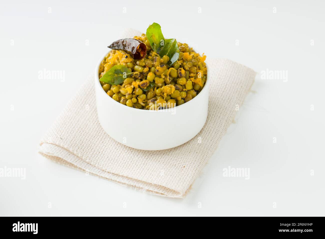Green gram stir fry or mung bean dry fry,kerala common dish which is very healthy and tasty and it is arranged in a white bowl with white textured bac Stock Photo