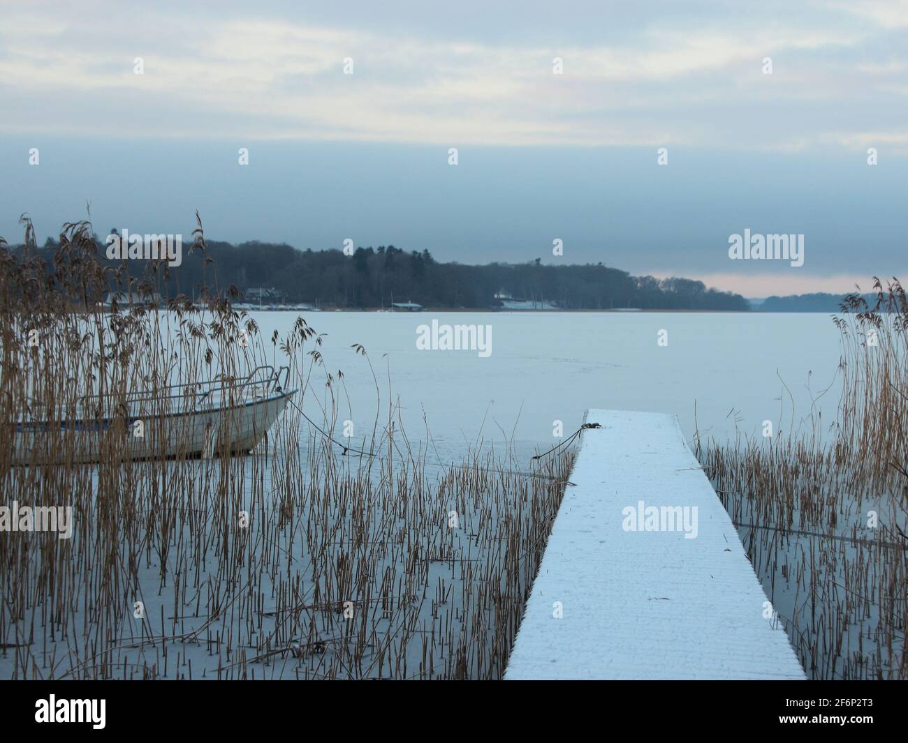 Perspective of Wooden Bathing Pier with Winter Snow and Frozen Lake Stock Photo