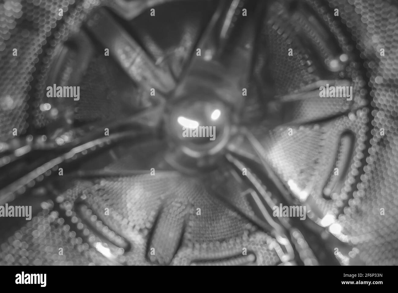 Washing machine drum silver metal color, blurred background close-up. Stock Photo