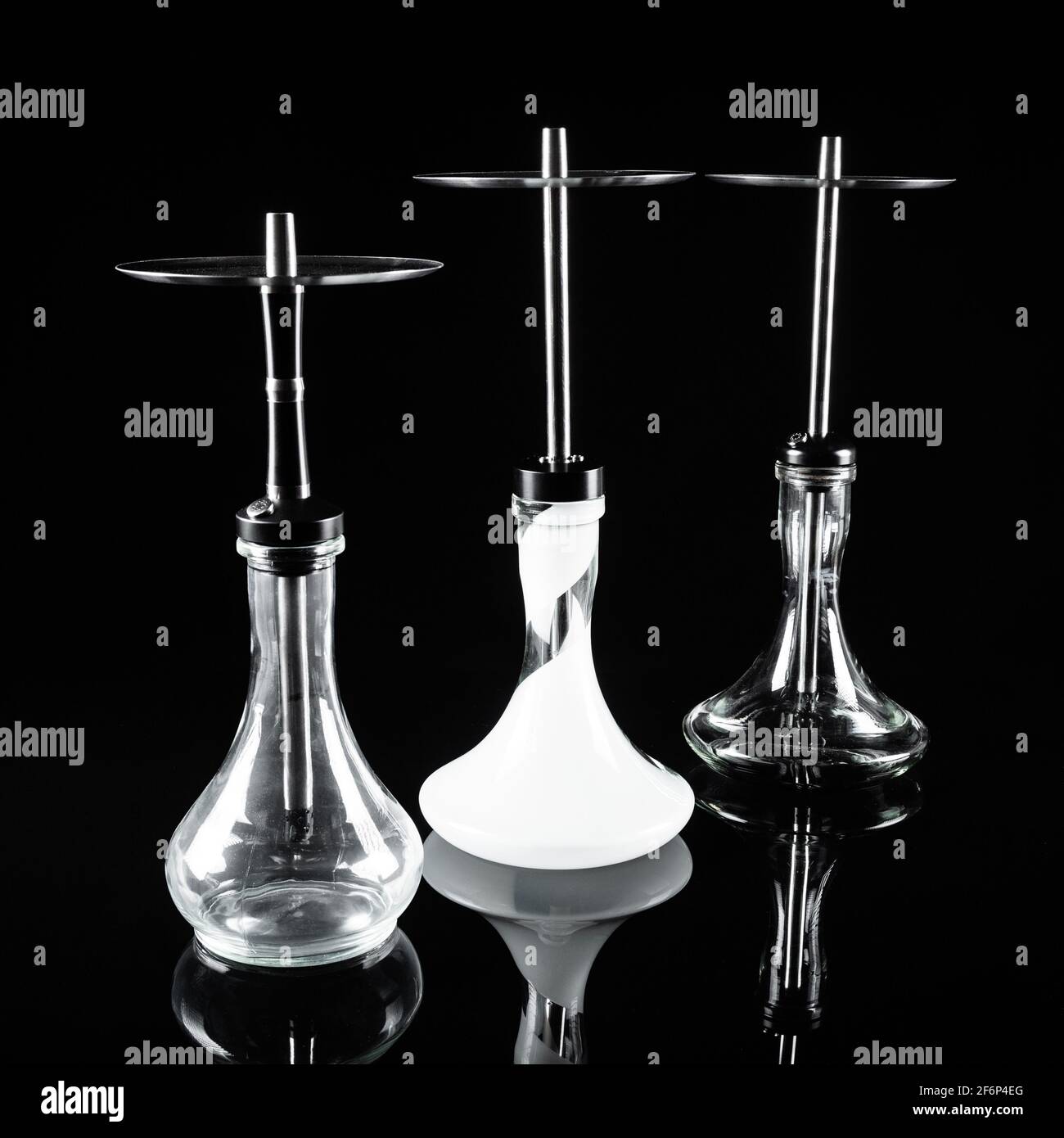 Three hookahs on a black mirror background. Stock Photo