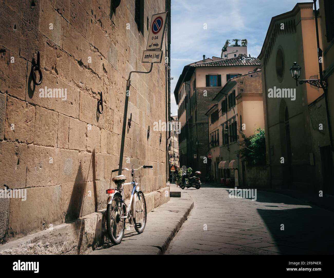 View of Bicycle on Traditional Italian Streets and Urban Setting with Summer Sun, Florence, Italy Stock Photo