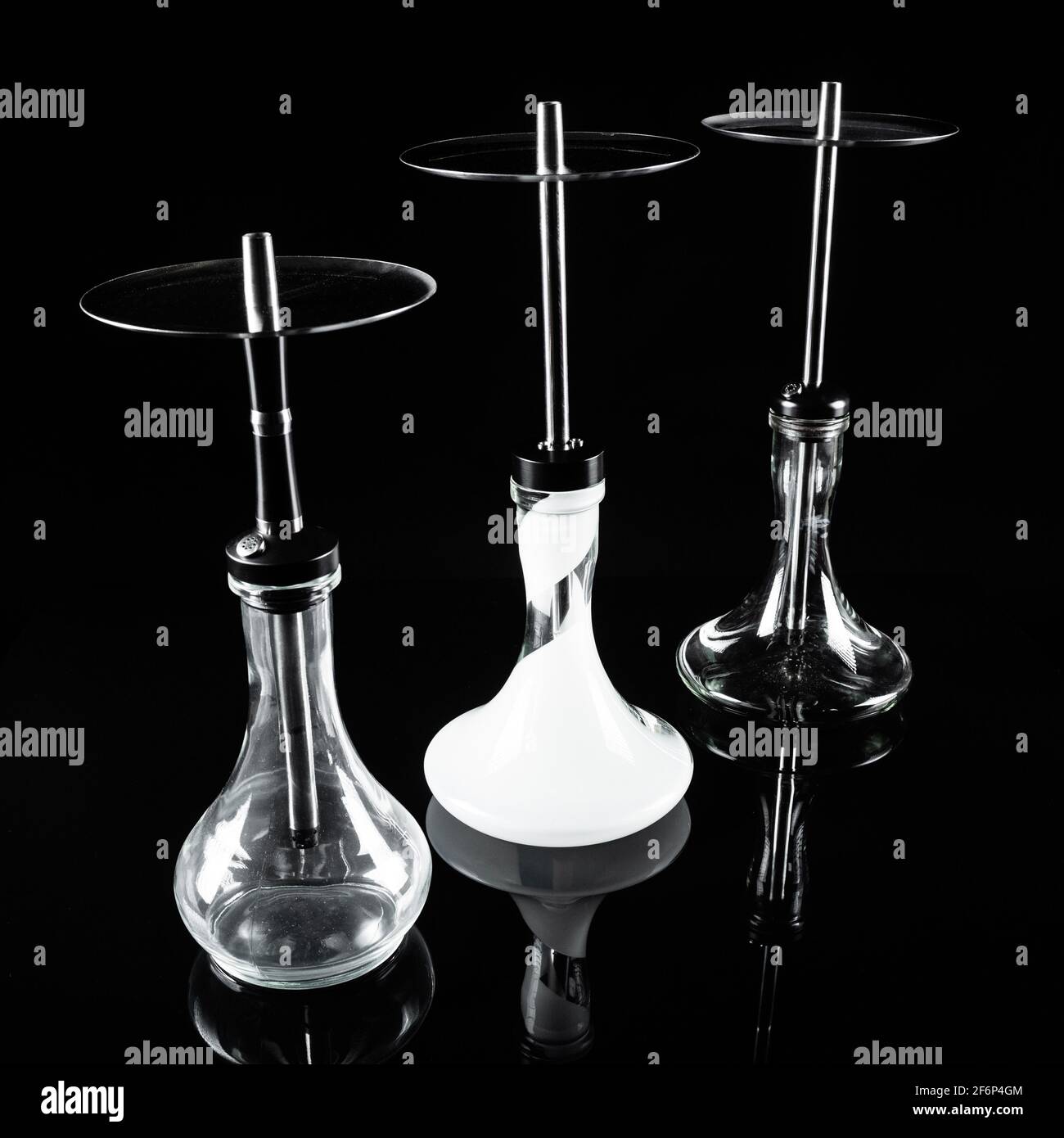 Three hookahs on a black background with a reflection. Stock Photo