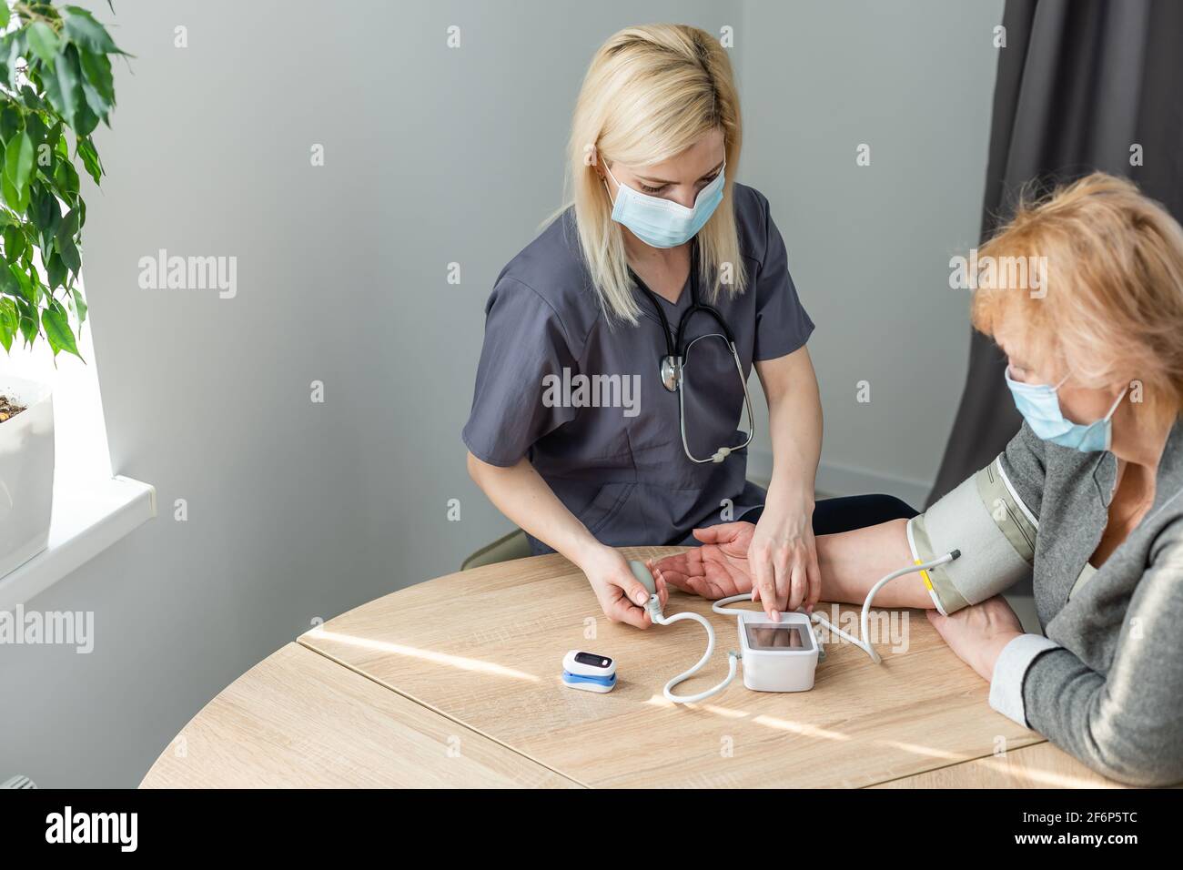 Doctor measuring blood pressure of senior patient Stock Photo - Alamy