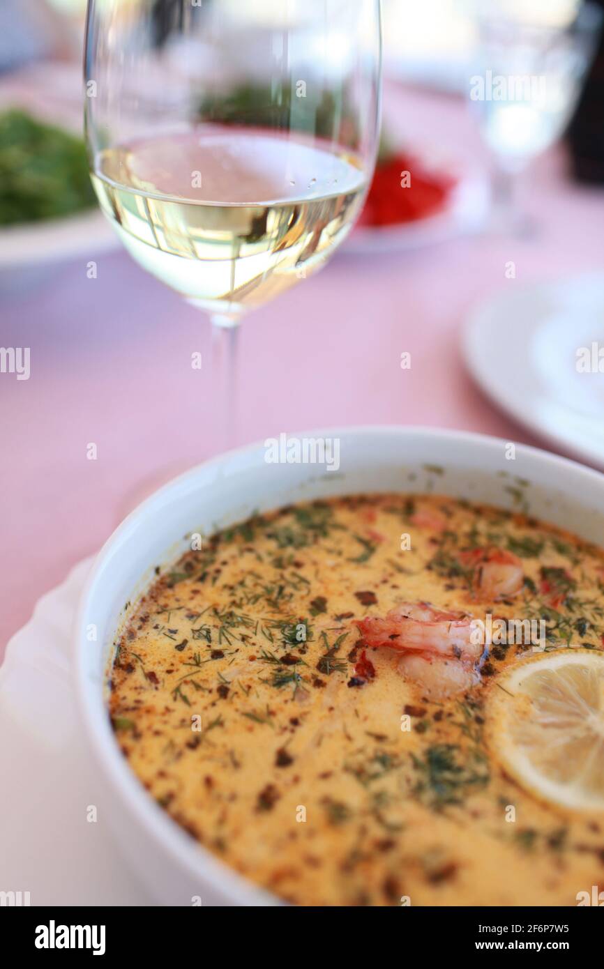 French fish soup bouillabaisse most popular in Marseille, here is photographed with a glass of the French wine chablis in popular Odessa restaurant. Stock Photo