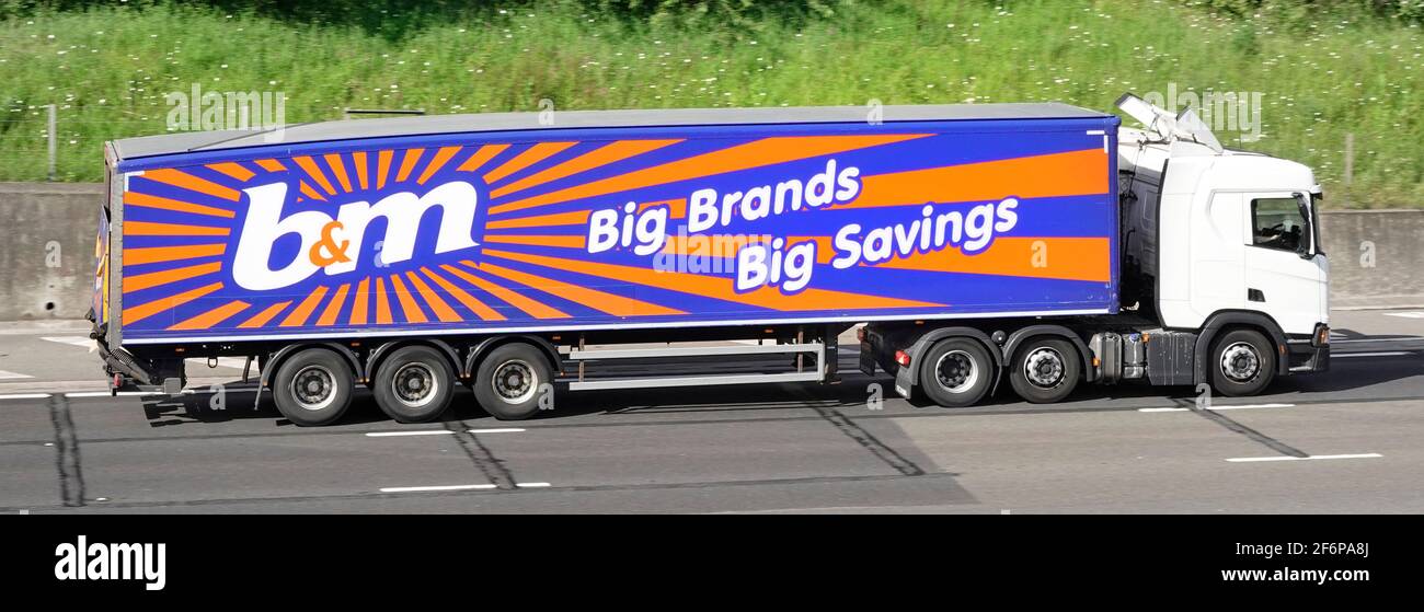 Side view b&m retail supermarket business supply chain delivery lorry truck & articulated trailer with brand advertising logo graphic on UK motorway Stock Photo