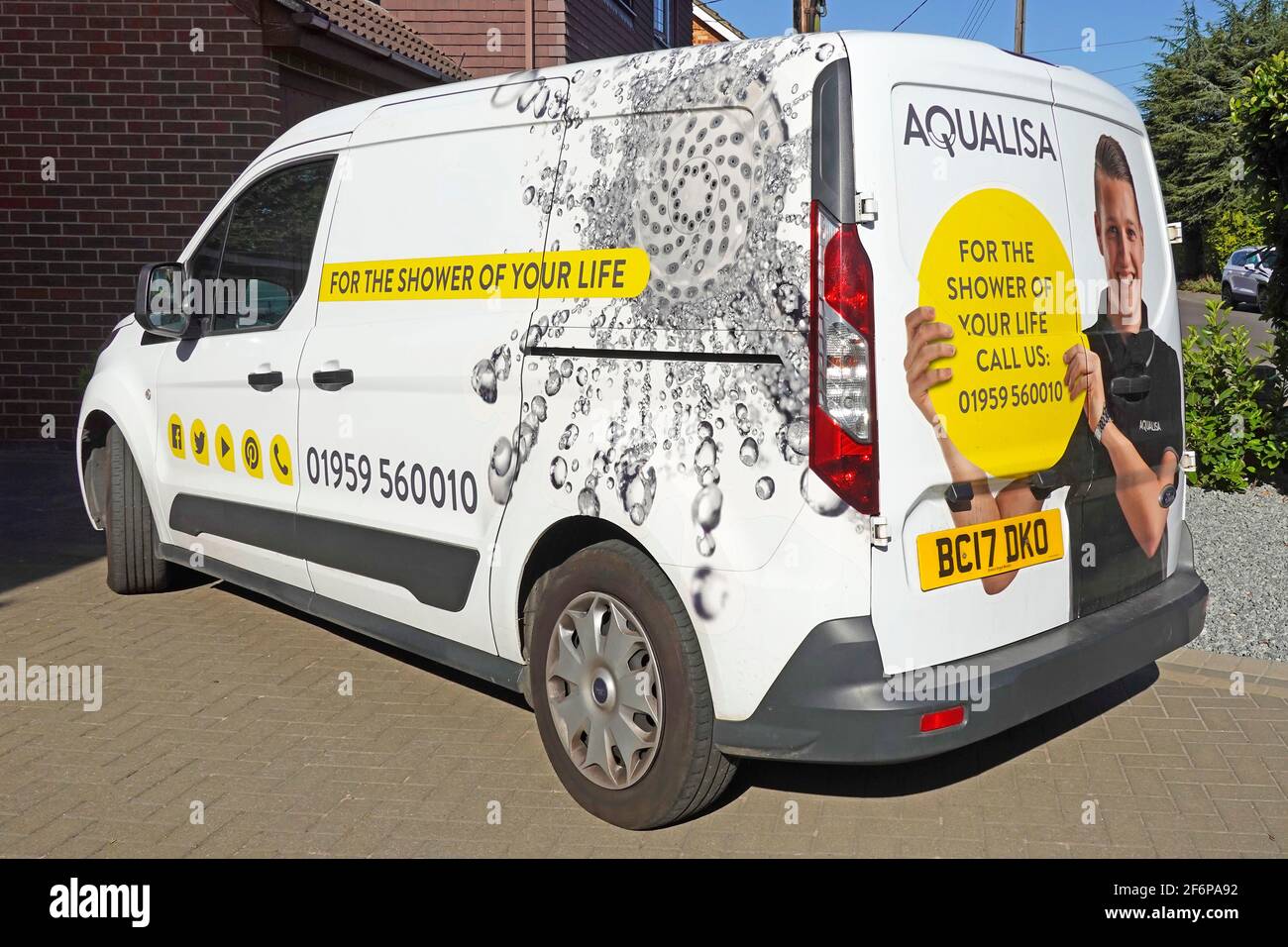 Close up side & back view graphic on installers white van advertising a home shower installation & improvement business parked on customers drive UK Stock Photo