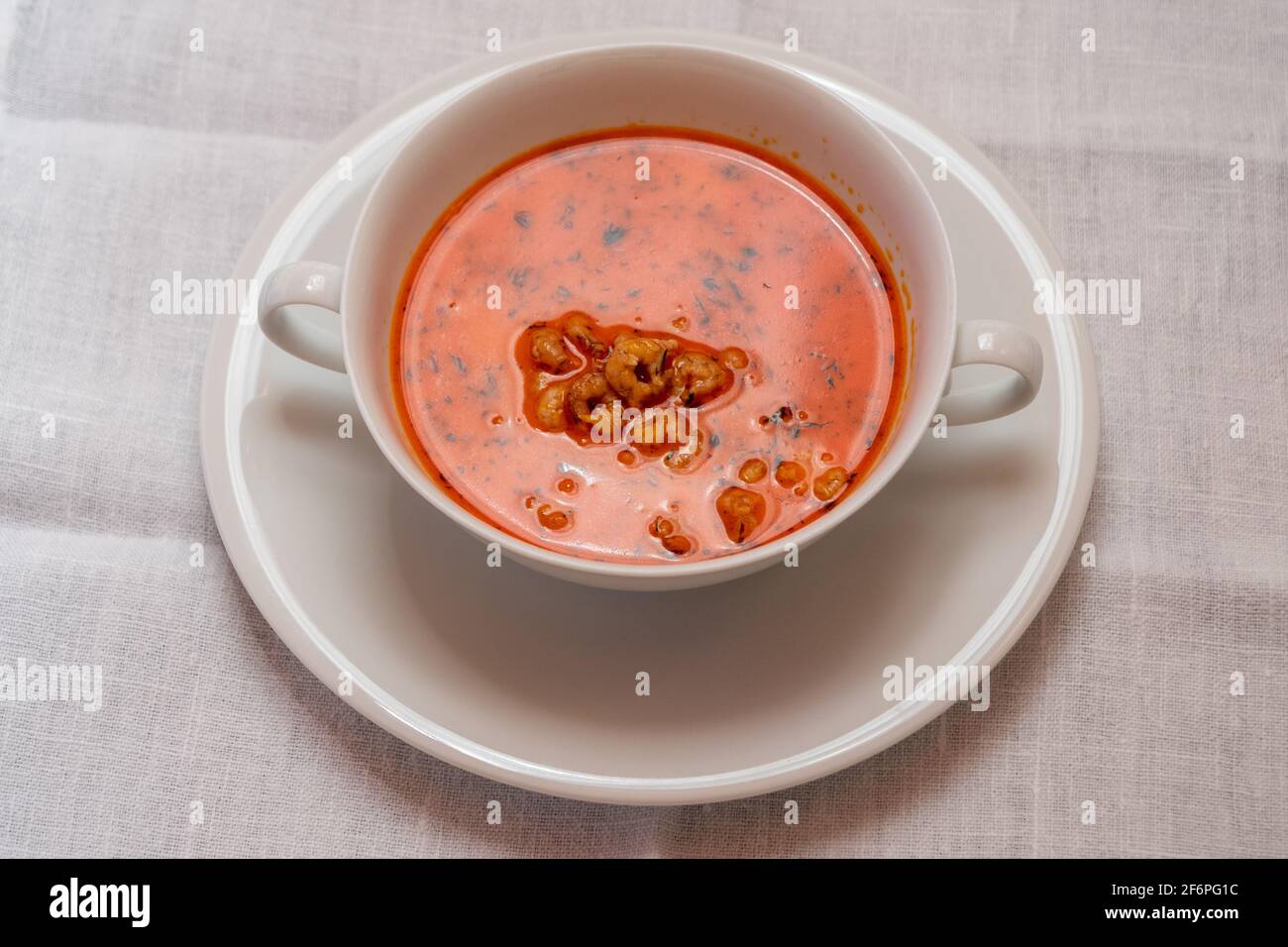 Busumer Krabbensuppe, Busom Style Soup with North Sea Crabs in a White Bowl, Served with a Slice of Bread Stock Photo