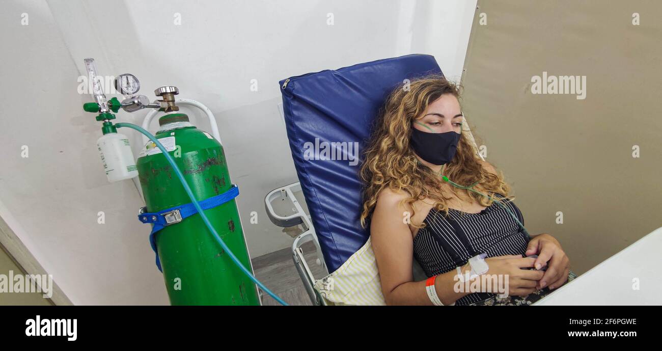 Young Brazilian woman undergoing treatment against covid-19 receiving ...