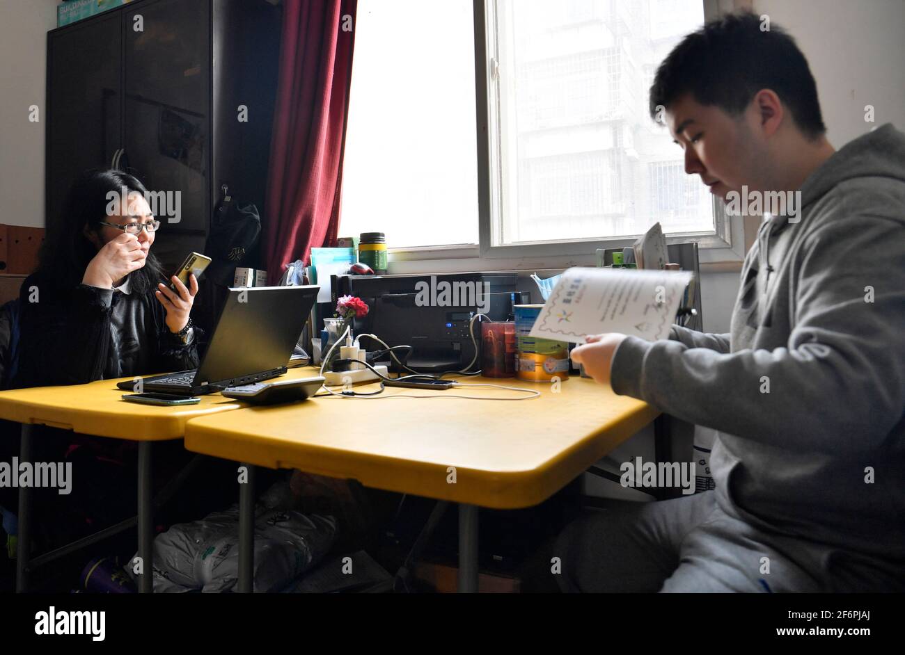 (210402) -- TIANJIN, April 2, 2021 (Xinhua) -- Wu Guixiang (L) and her son Zhang Hao are seen at the autism training center she set up in Hedong District, north China's Tianjin, March 30, 2021.  In 1998, Zhang Hao was diagnosed with autism at the age of two. Ever since the diagnosis, Zhang's mother Wu Guixiang has spent all her time looking after her son.    In order to help Zhang Hao and eight others with autism improve their social engagement after they had become grown-ups, Wu set up an autism training center in 2016, providing them with courses on life, social and vocational skills.   With Stock Photo