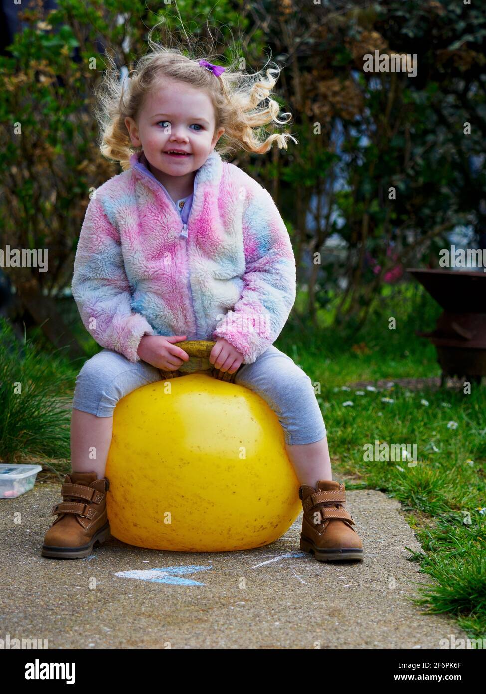 Toddler bouncing on a Space Hopper, UK Stock Photo