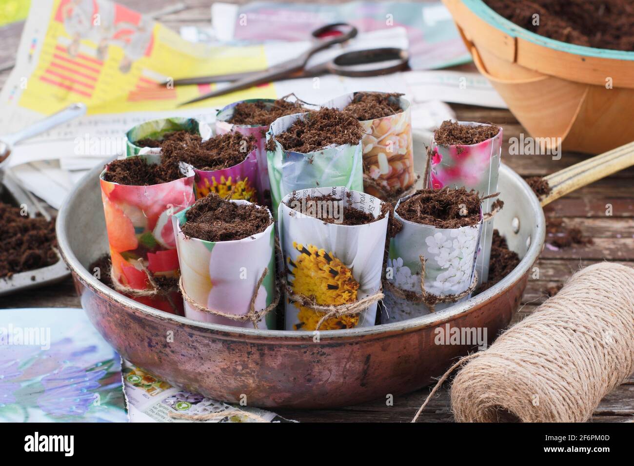 Paper plant pots. Items needed for making paper plant pots to start off seeds - old newspapers and catalogues, scissors, string. Stock Photo