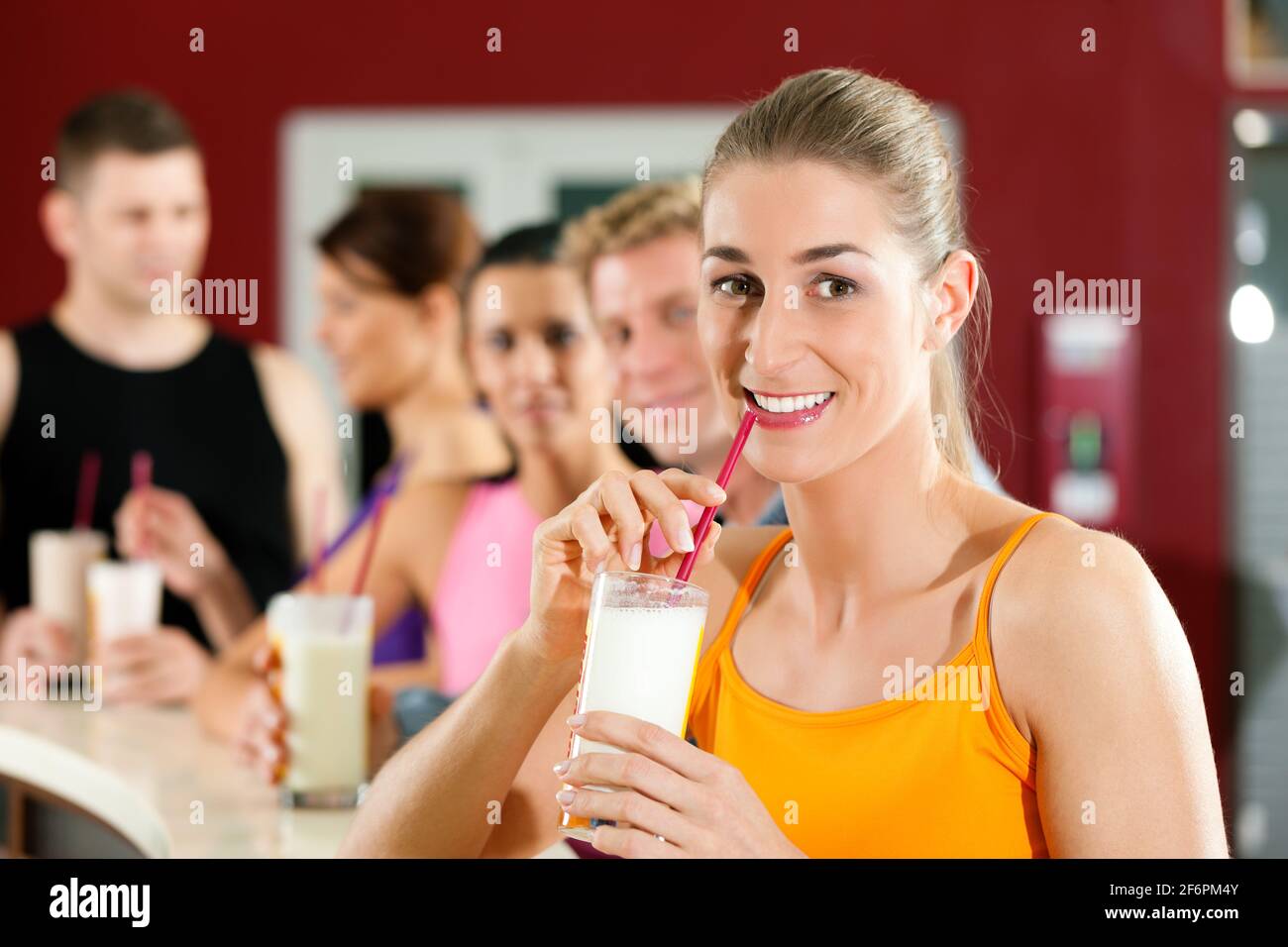 People drinking protein shake after workout in gym or fitness club Stock Photo