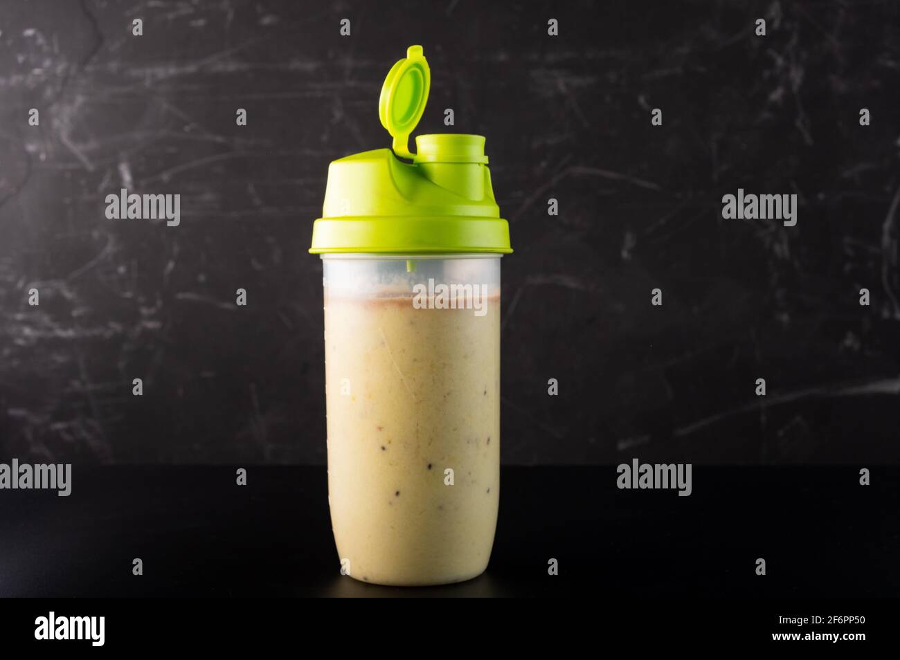 Shaker with fruit and protein drink. Shaker isolate on a dark background. Stock Photo