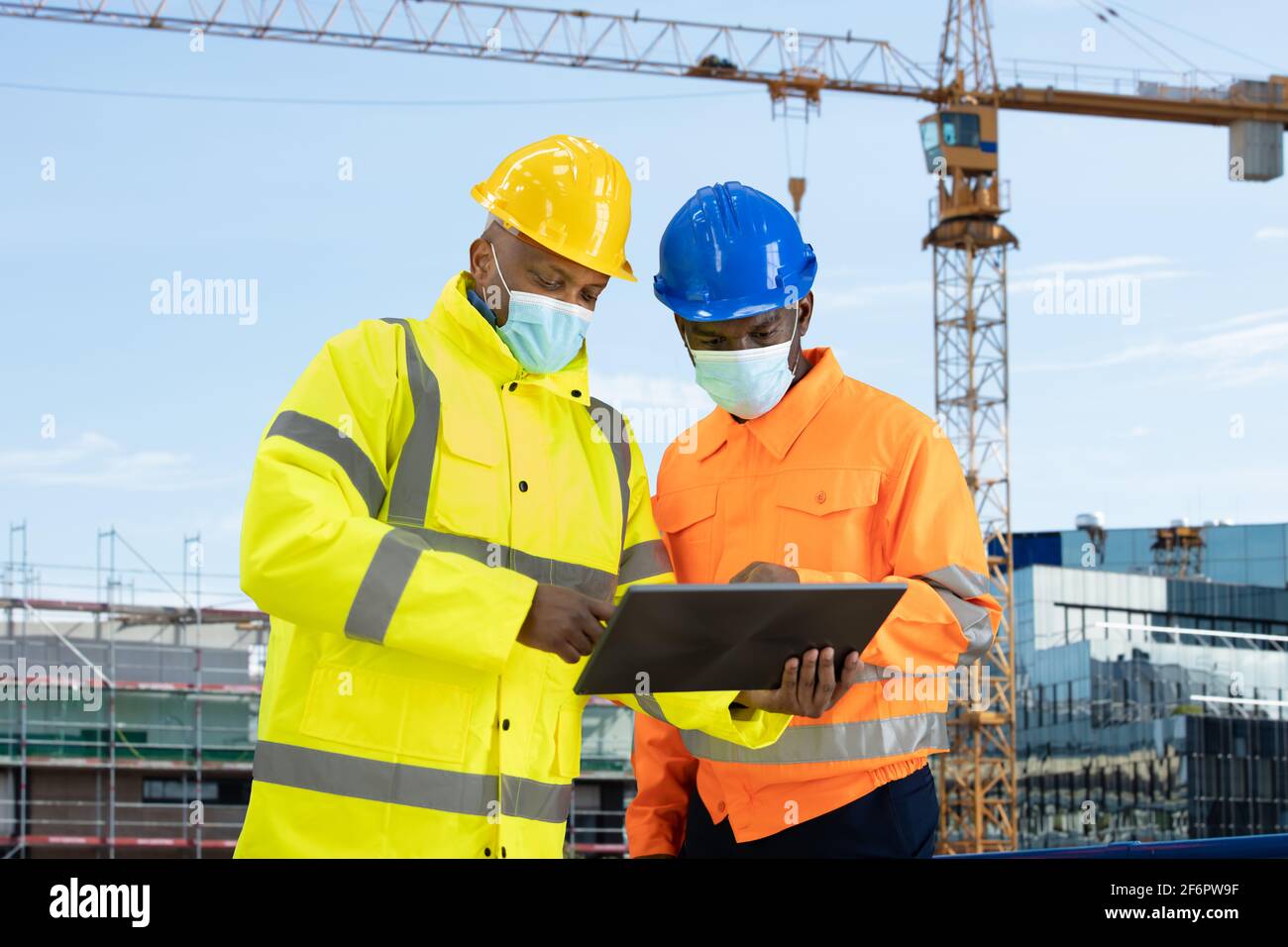 Construction Site Engineer And Building Inspection Looking At Tablet Stock Photo