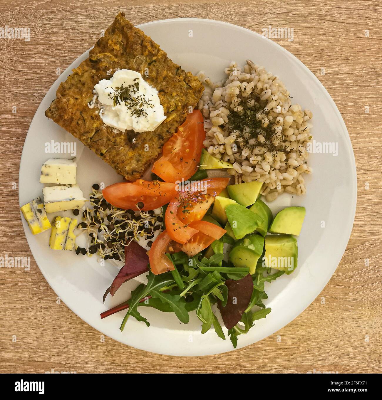 Cooked pearl barley, a piece of vegetable casserole with cream or