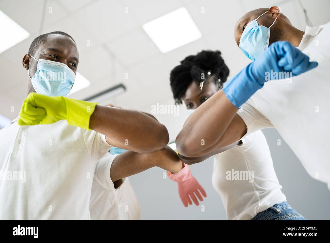 Janitor Cleaner Team In Uniform Elbow Bump Stock Photo