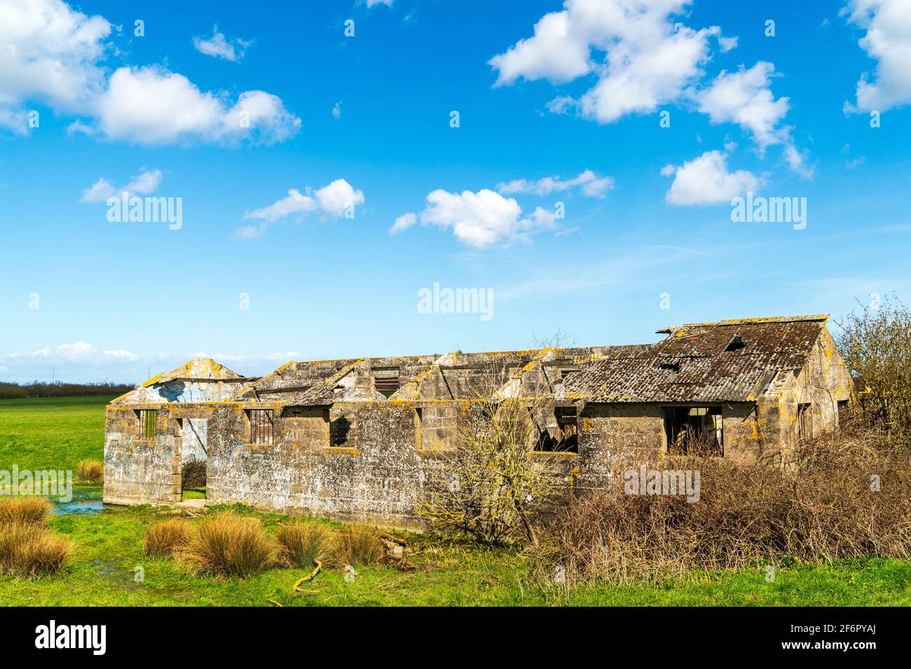 Abandoned one story breeze block roofless building formally used as a world war one prison out on farmland at Richborough, Kent. Blue sky, springtime. Stock Photo