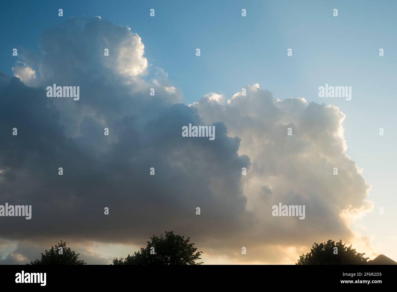 Beautiful rim lighting in growing cumulo-nimbus thunder clouds. Stock Photo
