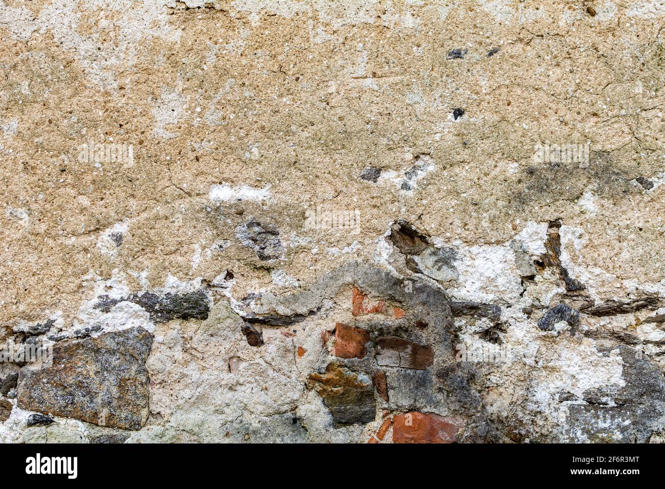 Old damaged dirty wall with cracks and wholes. Ruin facade made of natural stone and Bricks. A vintage background for design Stock Photo
