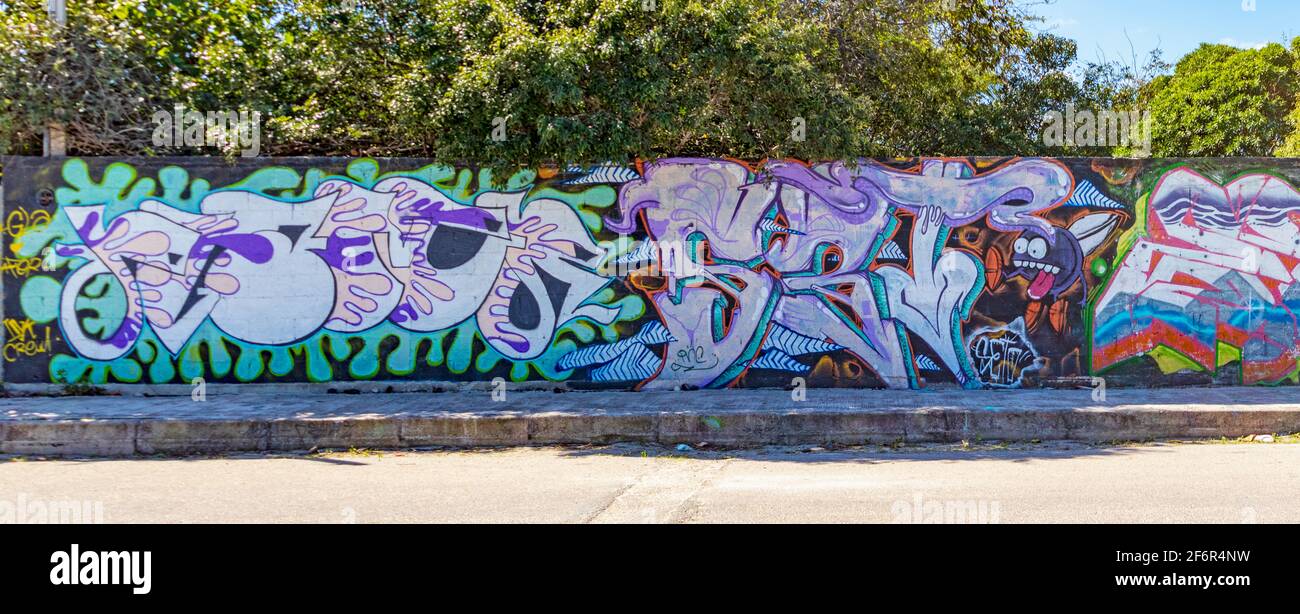 Colorful street art in a small town on garden walls along the sidewalk