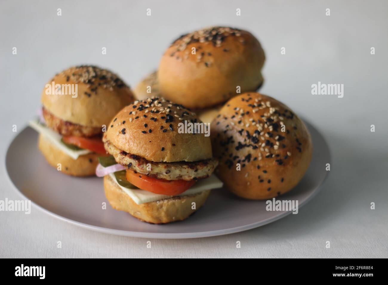 Burger bread with sesame is heating on a grill pan. Process of cooking self  made burgers at home Stock Photo - Alamy