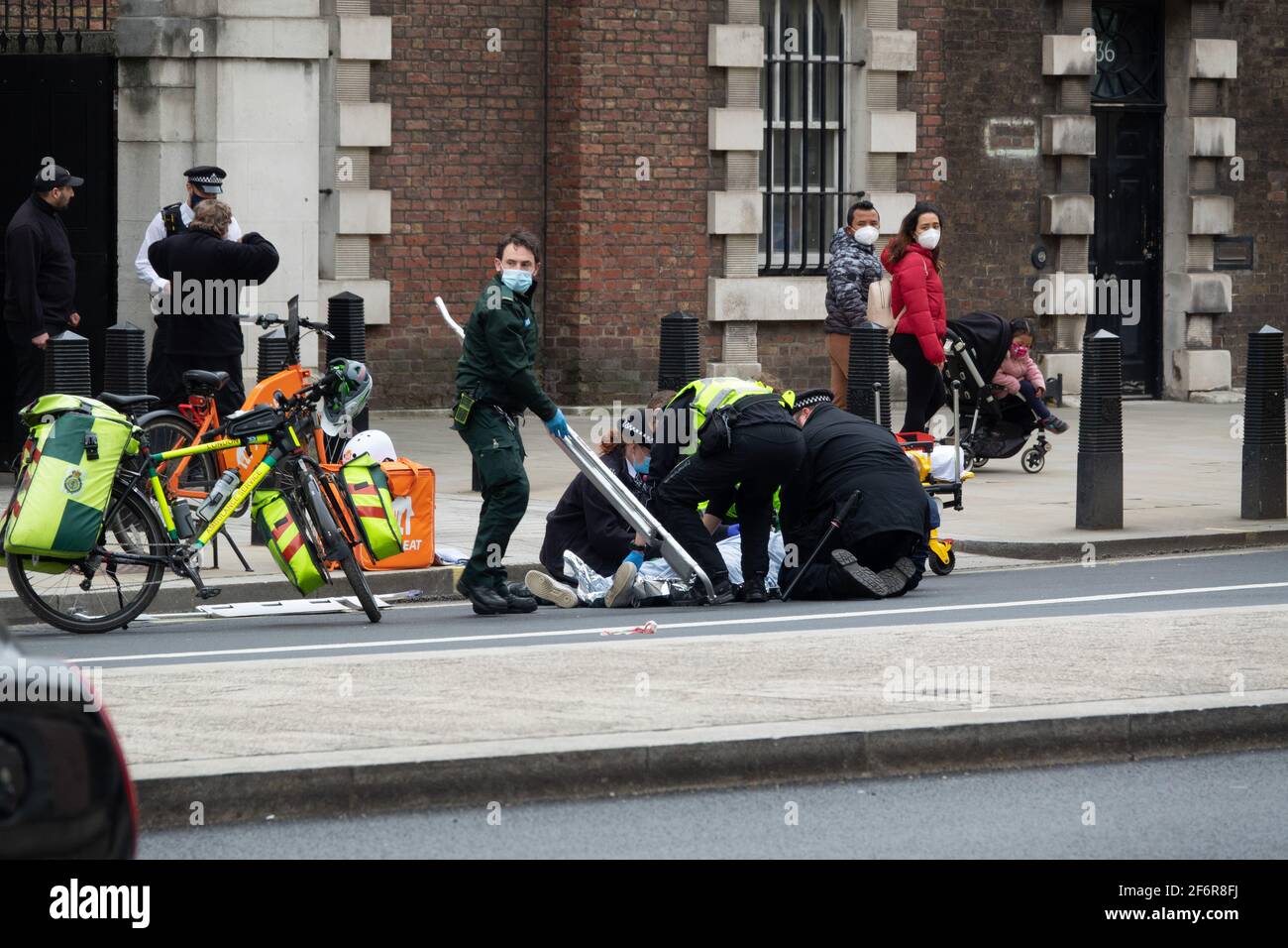 London, UK. 2nd April 2021. Police and London Ambulance Service attend to a Just Eat delivery cyclist on Whitehall Road following an road traffic collision or rtc. Stock Photo