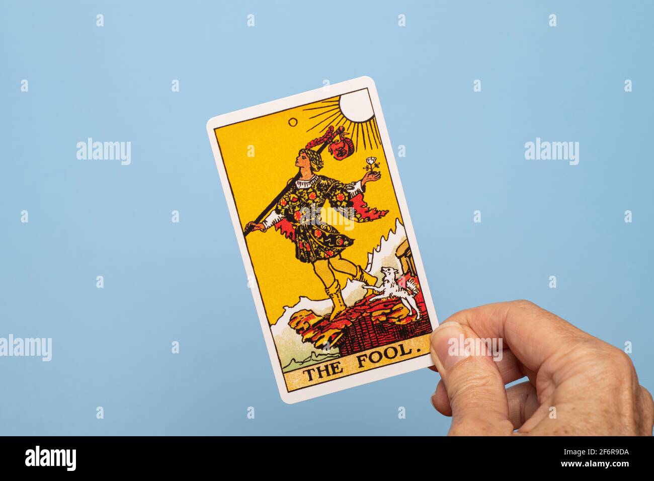 Hand holding the Fool tarot card. Stock Photo