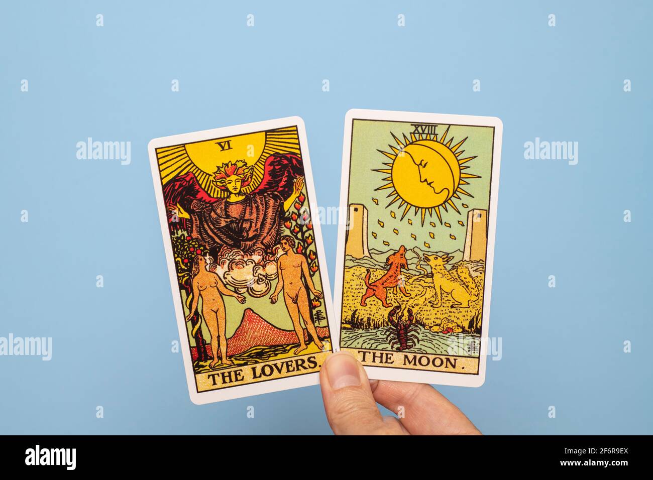 Hand holding two Tarot cards, The Moon and The Lovers. Stock Photo