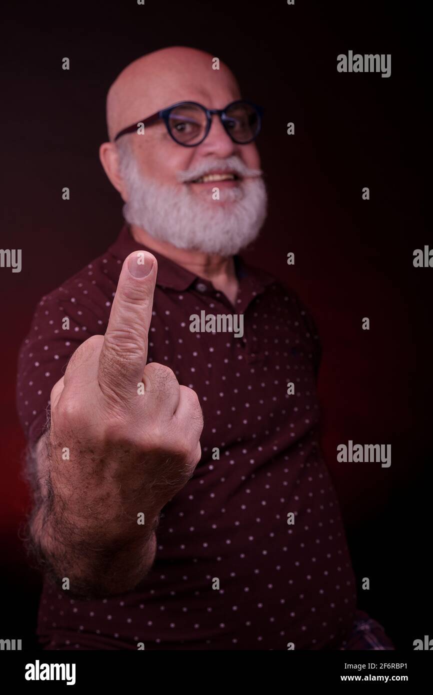 Senior man shows his finger in a naughty behaviour. Stock Photo