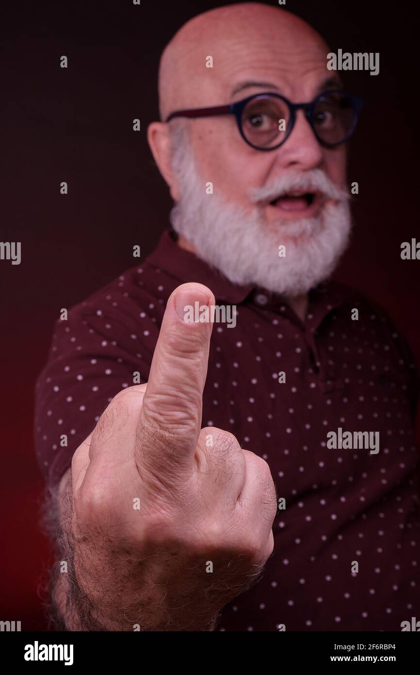 Senior man shows his finger in a naughty behaviour. Stock Photo