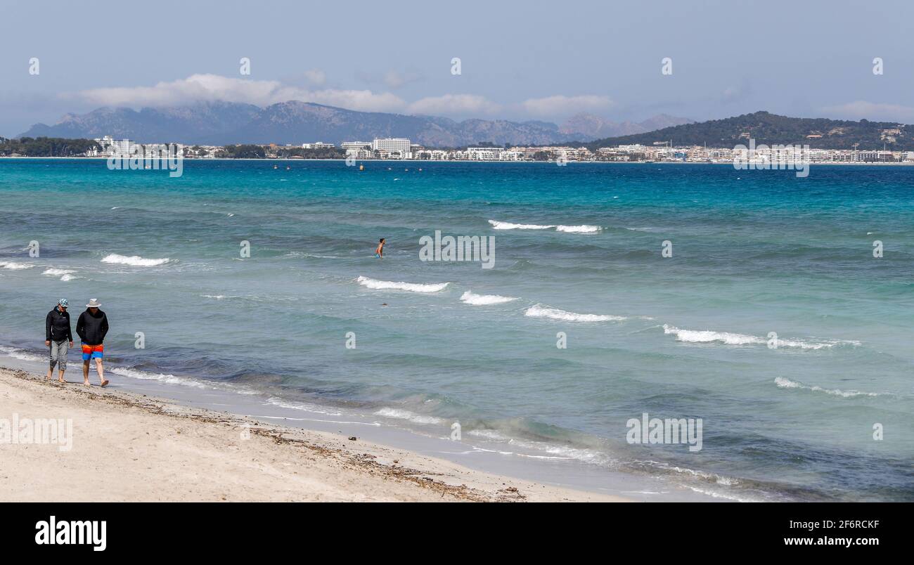 Muro, Spain. 02nd Apr, 2021. A couple walks along the beach. Despite all the appeals from the German government to refrain from travelling in the face of high Corona numbers, industry estimates suggest that around 40,000 Germans will spend their holidays in Mallorca over Easter. Credit: Clara Margais/dpa/Alamy Live News Stock Photo