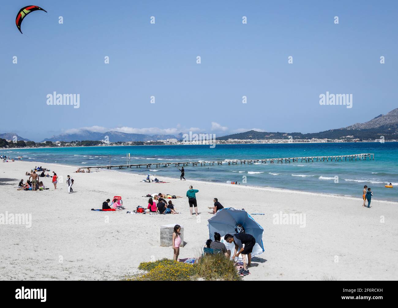 Muro, Spain. 02nd Apr, 2021. People spend their leisure time on the beach. Despite all the appeals from the German government to refrain from travelling in view of high Corona numbers, industry estimates suggest that around 40,000 Germans will spend their holidays on Mallorca over Easter. Credit: Clara Margais/dpa/Alamy Live News Stock Photo