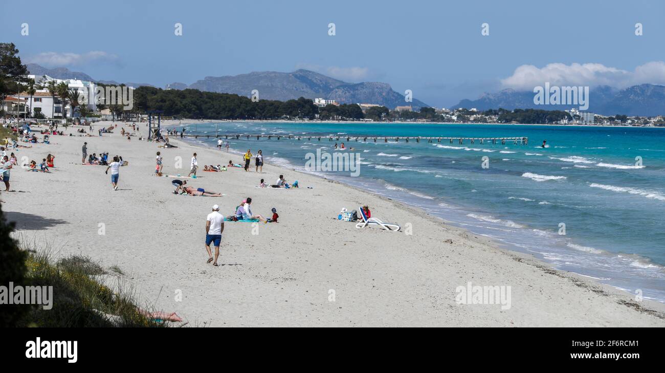 Muro, Spain. 02nd Apr, 2021. People spend their leisure time on the beach. Despite all the appeals from the German government to refrain from travelling in view of high Corona numbers, industry estimates suggest that around 40,000 Germans will spend their holidays on Mallorca over Easter. Credit: Clara Margais/dpa/Alamy Live News Stock Photo