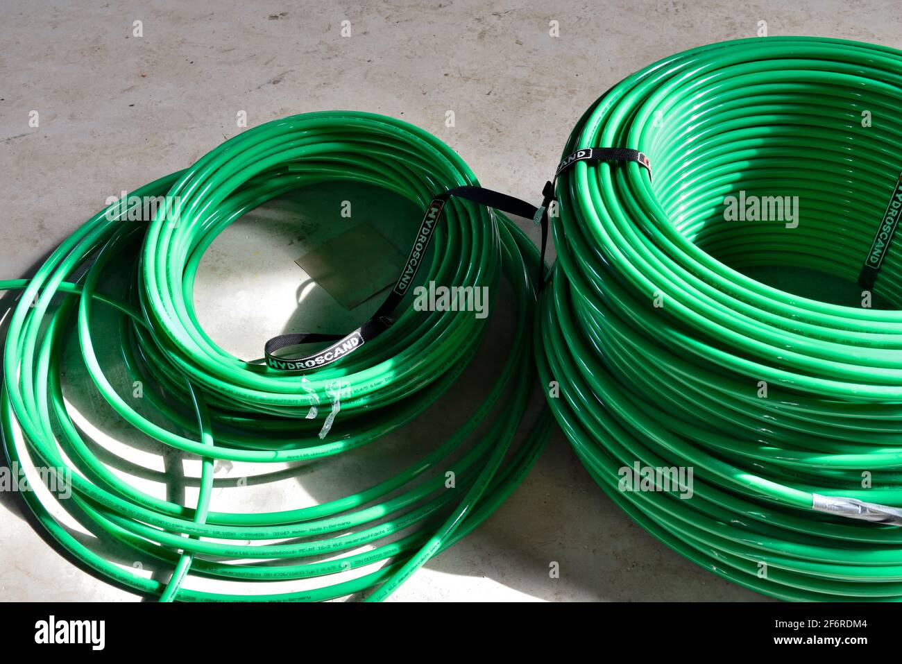 Coils of green plastic underfloor heating pipe Stock Photo Alamy