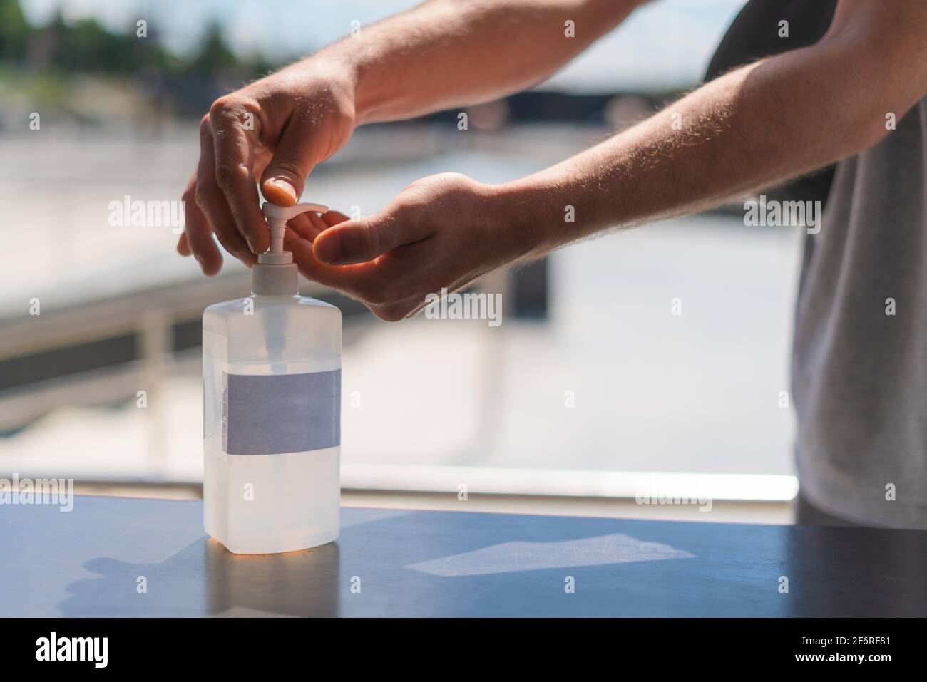Person using hand sanitizer gel in public. Hand pressing antibacterial