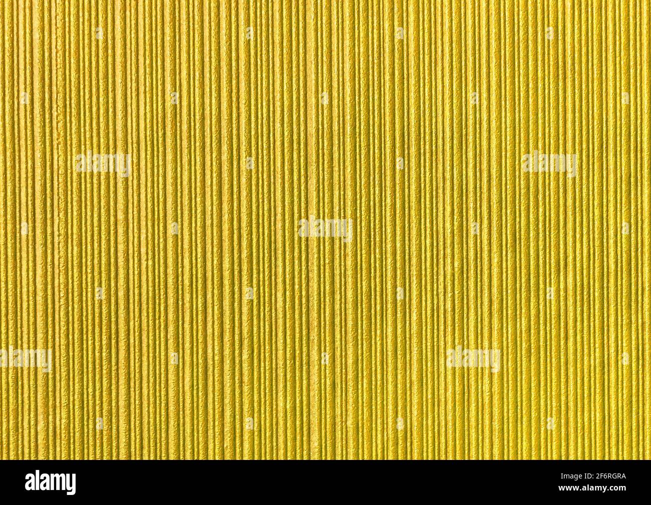 Yellow abstract striped pattern wallpaper background, gold paper texture with vertical lines. Stock Photo