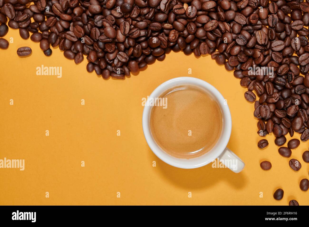 Cup of Coffee over yellow background and toast coffee beans Stock Photo