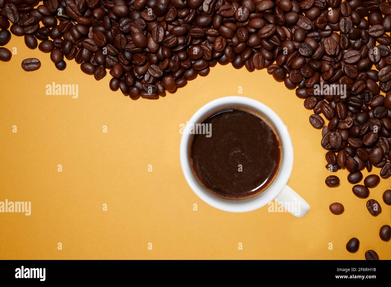 Cup of Coffee over yellow background and toast coffee beans Stock Photo