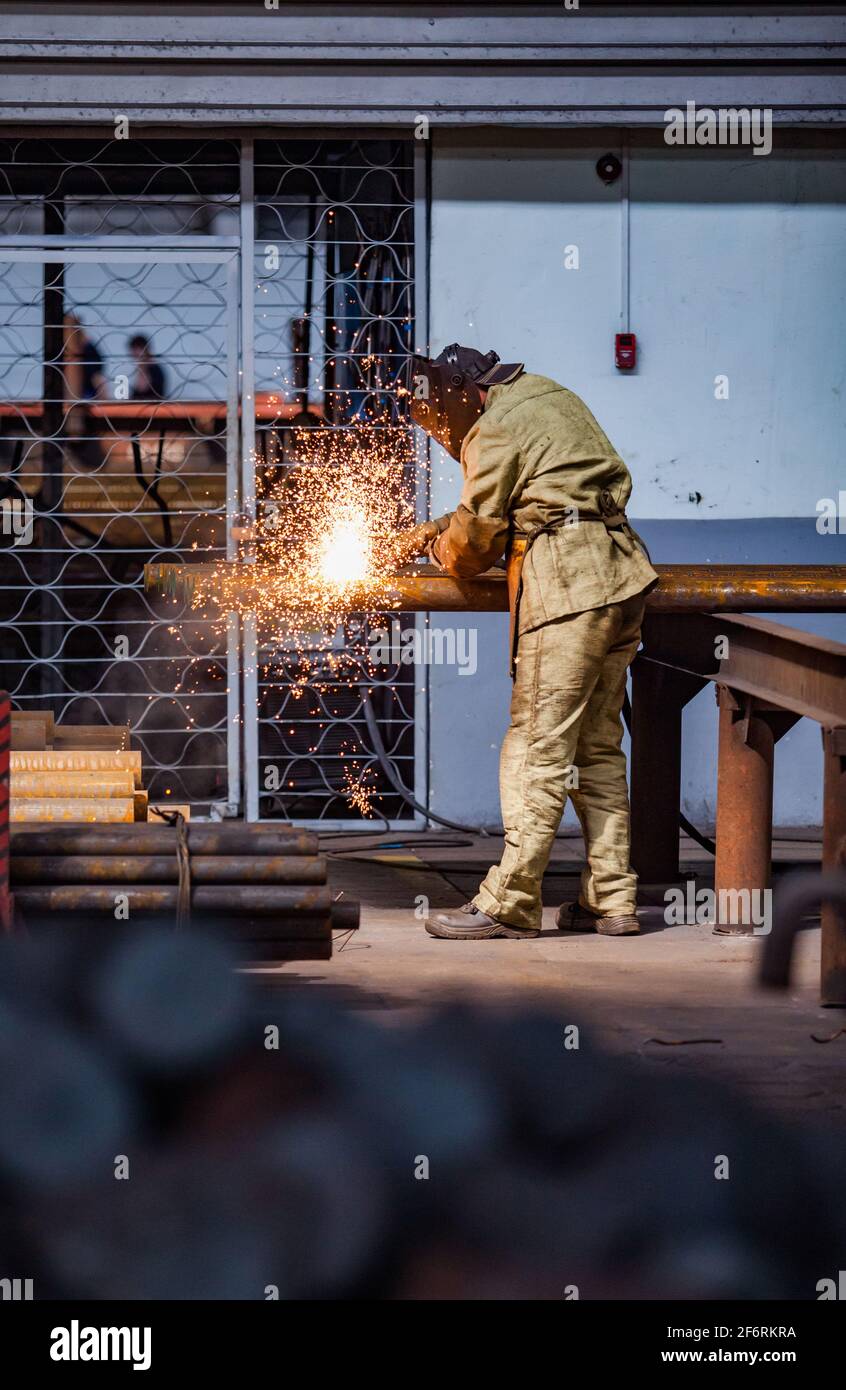 Welder worker welding steel tubes Stock Photo