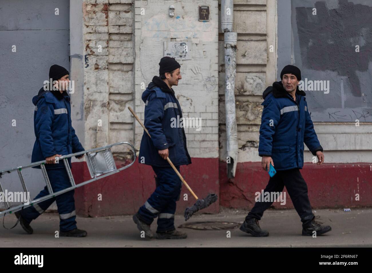 Employees of the municipal service walk down the street in the center of Moscow, Russia Stock Photo