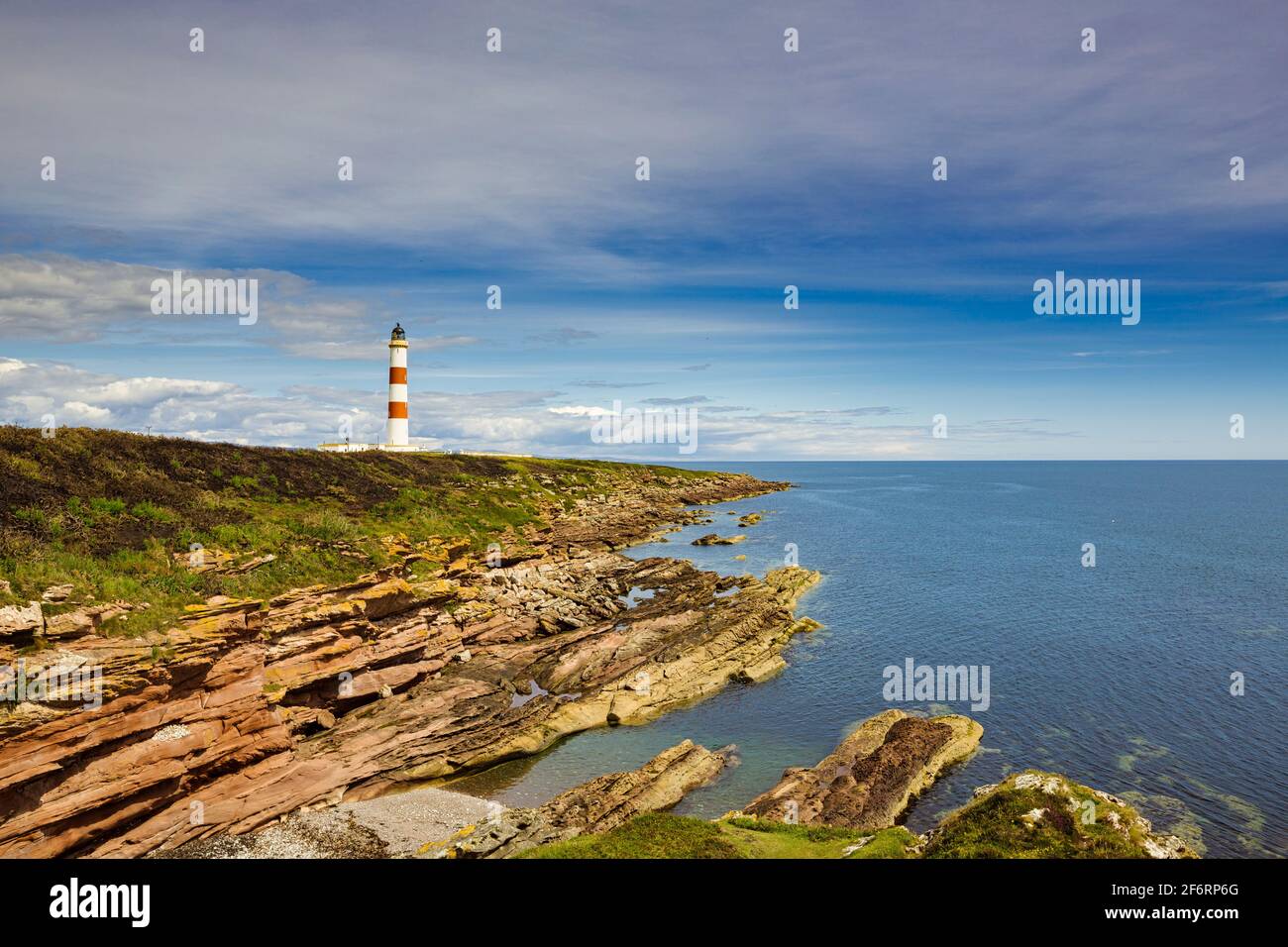 The rocky coastline of the Tarbat Ness peninsula with the lighthouse in the distance. Stock Photo
