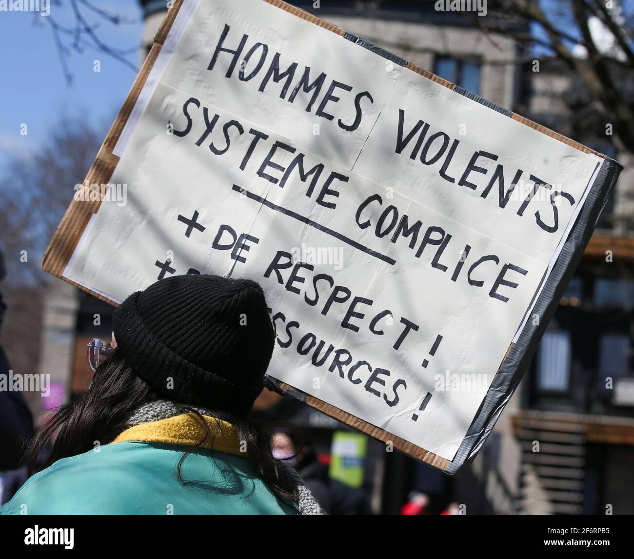 A woman carries a sign reading 'Violent men, complicit system, add respect and resources' during  a march in protest against domestic violence, after several women in the province were killed in recent weeks, in Montreal, Quebec, Canada April 2, 2021.   REUTERS/Christinne Muschi Stock Photo