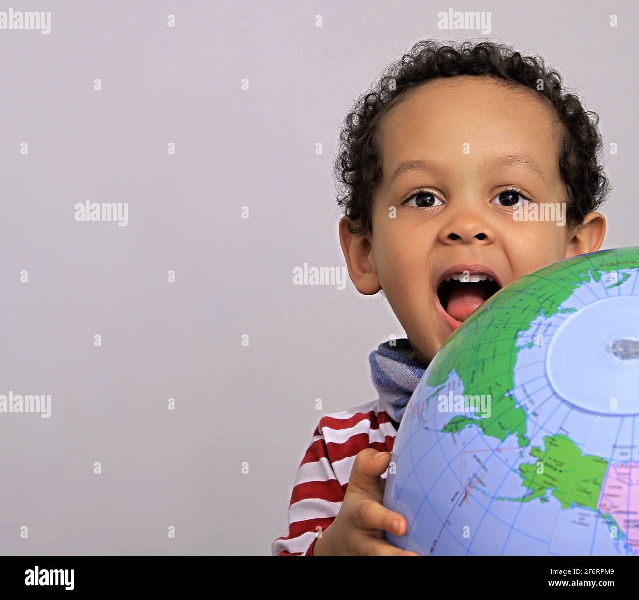 boy with globe looking up on white background stock photo Stock Photo