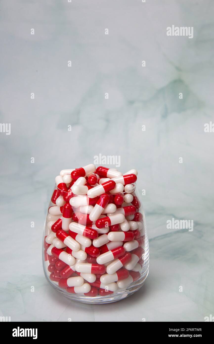 Filled glass with capsules pills for medication. drugs or vitamin