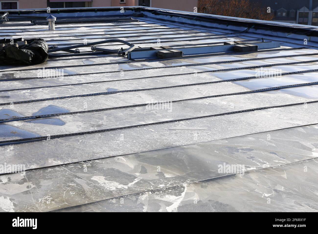 Roll seam welded stainless steel flat roof on a building. Stock Photo