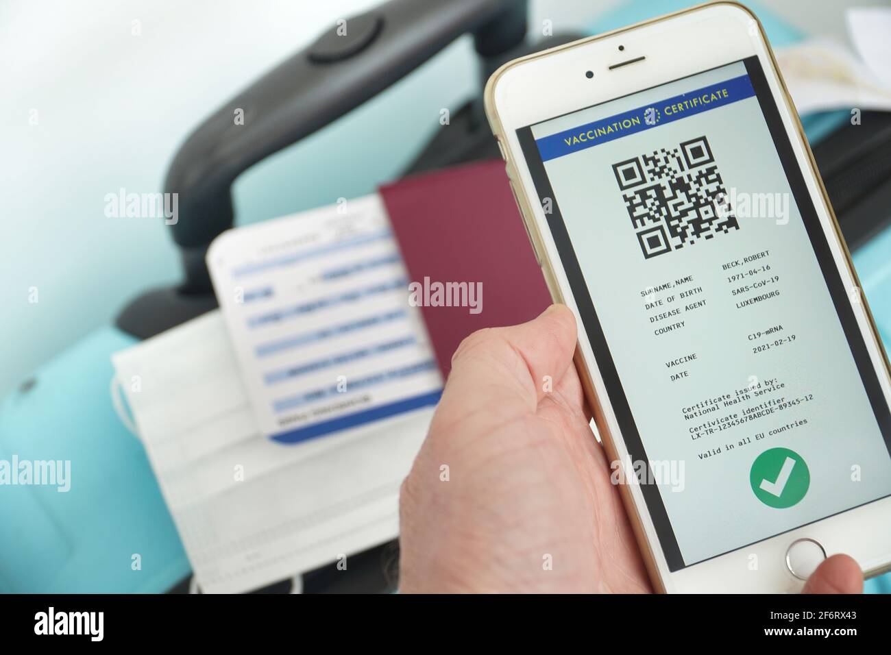 The digital green certificate of the european union with the QR code on the screen of a smart phone held by a hand in airport for travel. Vaccination Stock Photo