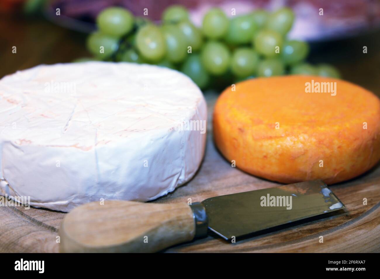 Cheese platter with different kinds of soft cheese and grapes. Stock Photo